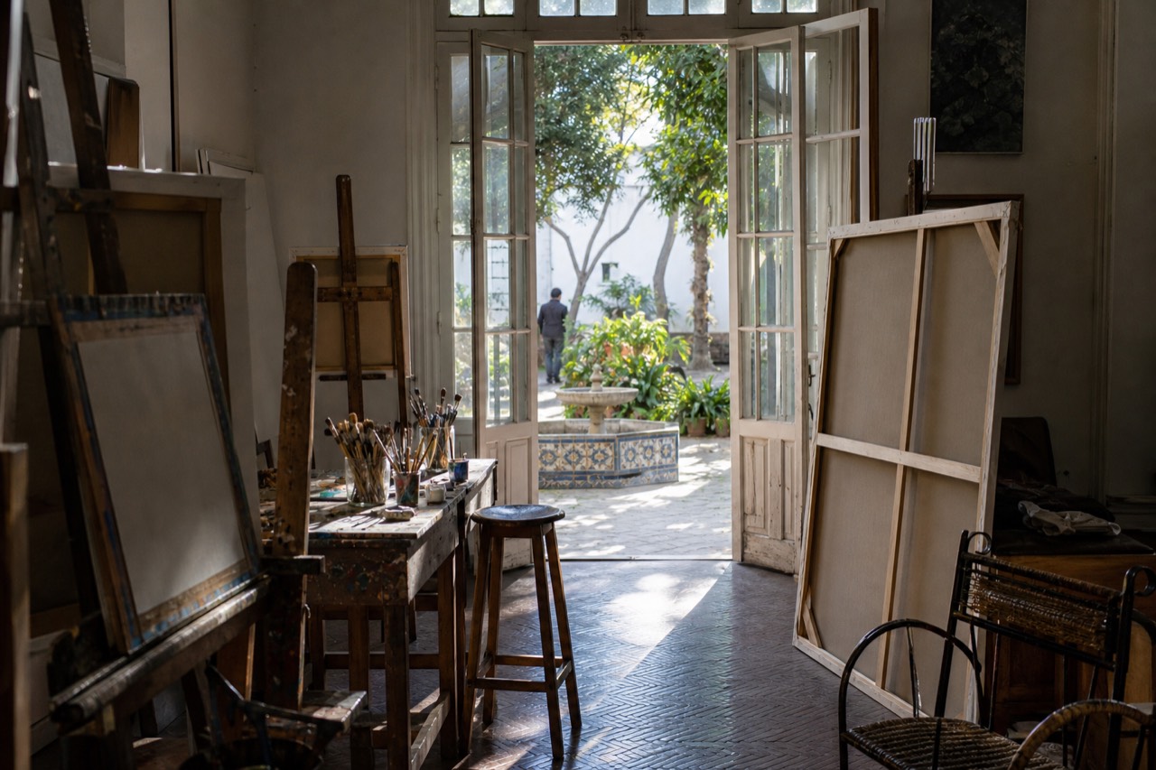 Sunlight falling through tall studio windows onto a bare wooden floor