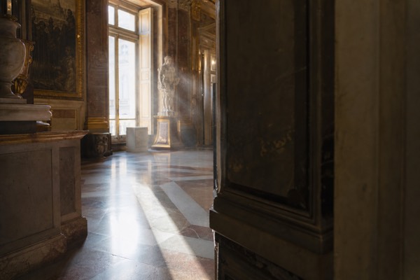 A gilded state room with a painted ceiling, crimson wall silk and visitors along a rope line